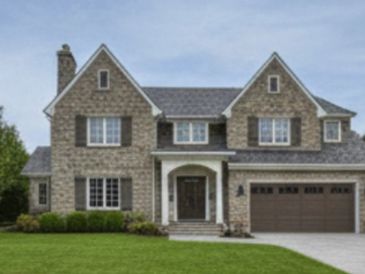 Two-story stone house with a large garage and front porch.