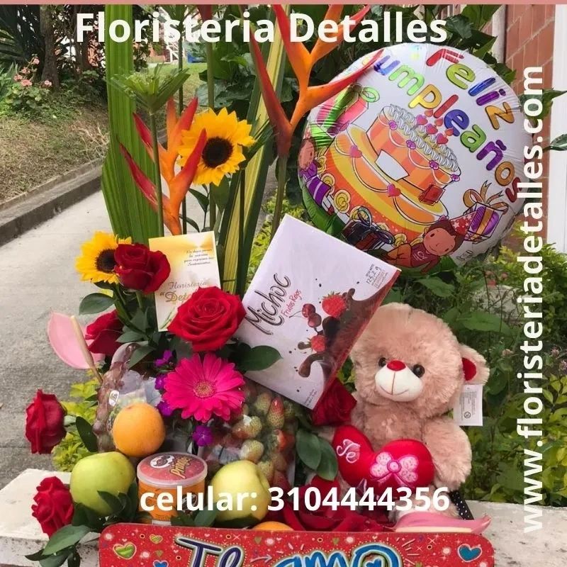 Colorful birthday gift arrangement with flowers, fruits, a teddy bear, and a balloon.
