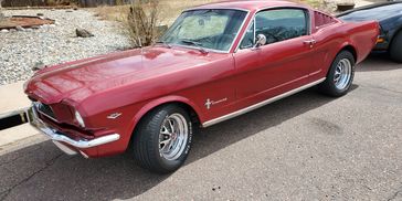 A classic red Ford Mustang parked on the street.