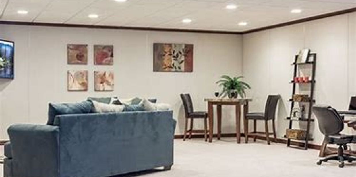 Cozy living area with a blue sofa, wall art, and a small dining table.