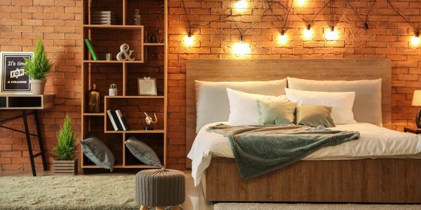 A view of a bed with hanging lights on the wall