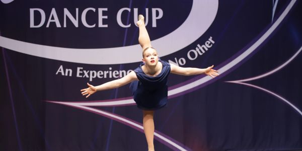 Young dancer performing a balancing pose at a dance competition.