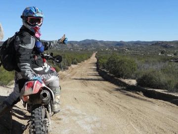 Jen Morton riding a Honda XR 650R on a road graded with donations. 