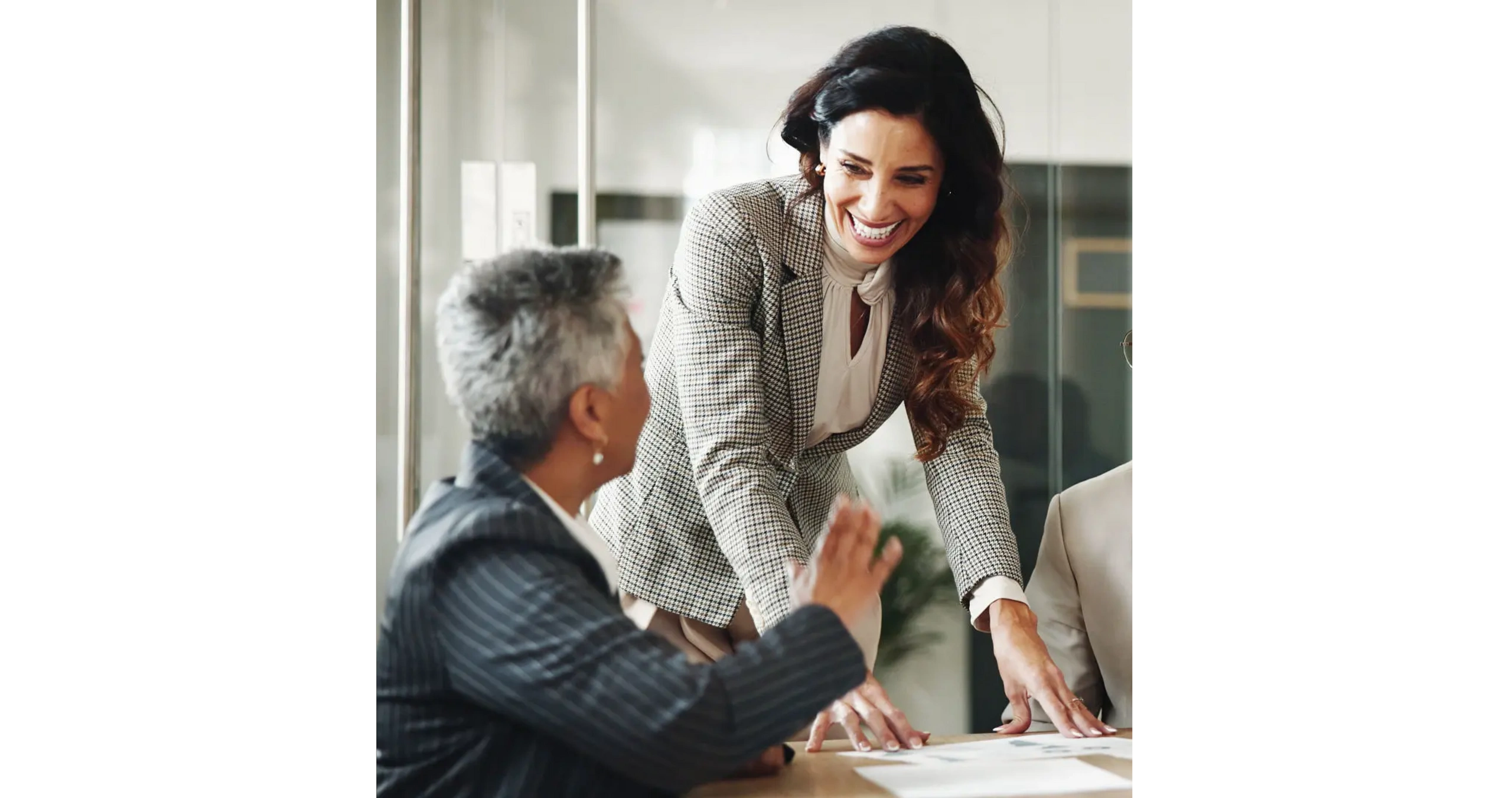 Two businesswomen engaging in a lively discussion during a meeting.