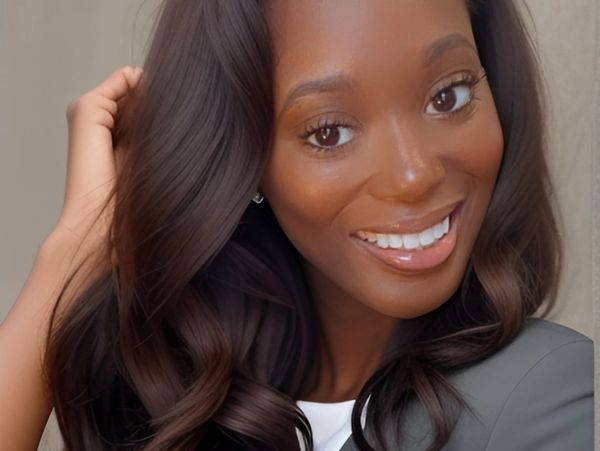 Smiling woman with long dark hair and a gray blazer.