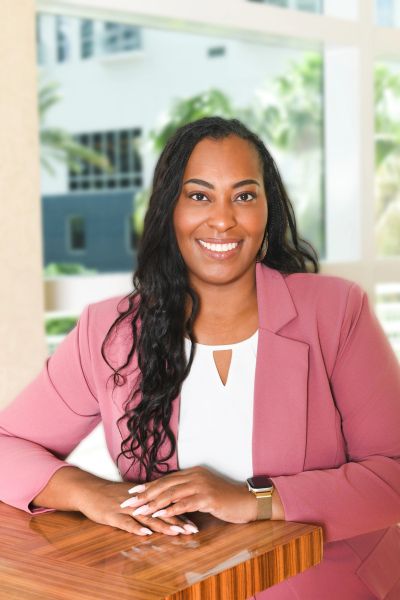 Dr. Kisha Jones, founder of KS Jones Solutions and management professor, smiling in a dusty rose bla