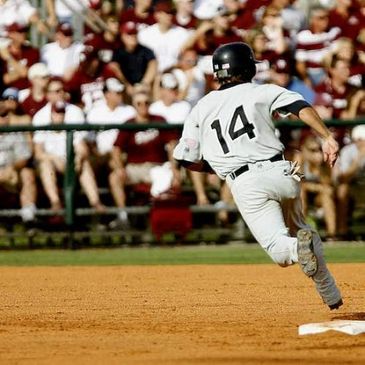 Baseball player wearing number 14 running on the field towards a base.