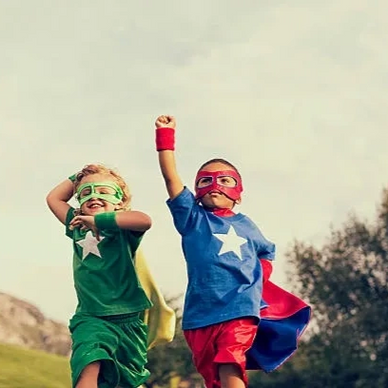 two young boys dressed up with capes and masks like super heros