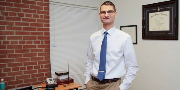 Man in office wearing white shirt and blue tie
