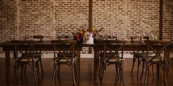 Rustic dining table with floral centerpiece and cake.