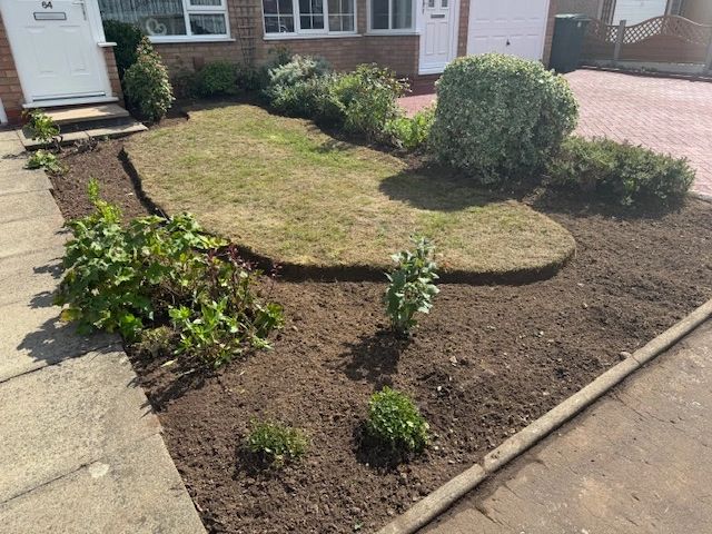 Front yard garden with trimmed lawn and new plants.