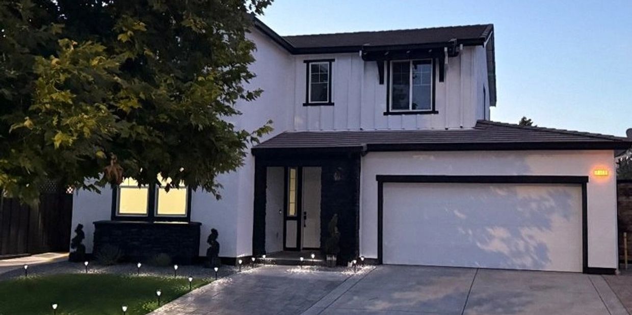 Finished exterior repaint of a white two-story home with black trim by A&R Bentley Painting