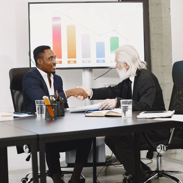 Two businessmen shaking hands in a meeting room.