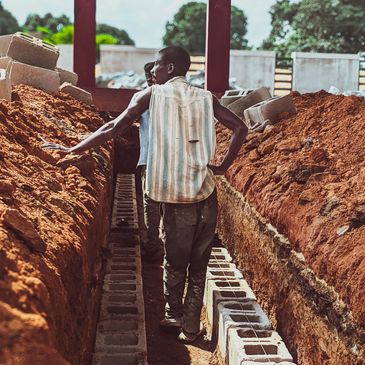 Man standing in a trench with concrete blocks.