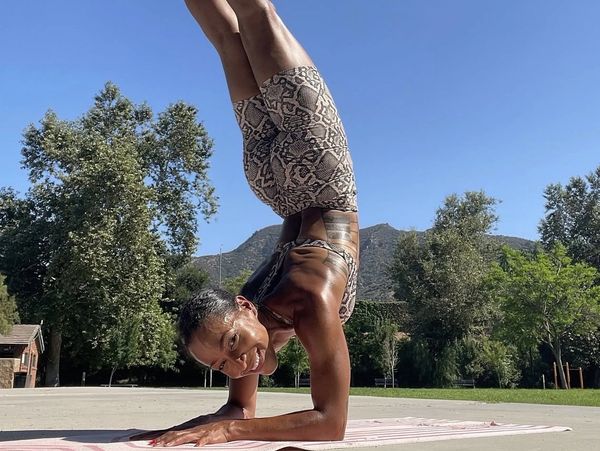 Woman doing a forearm stand yoga pose outdoors.