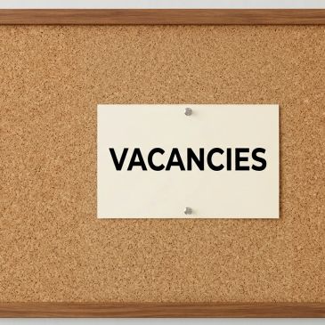 A cork bulletin board with a 'VACANCIES' notice.