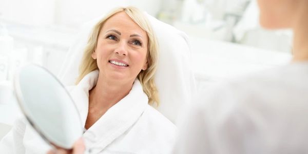 Blonde woman discussing treatment with her aesthetician