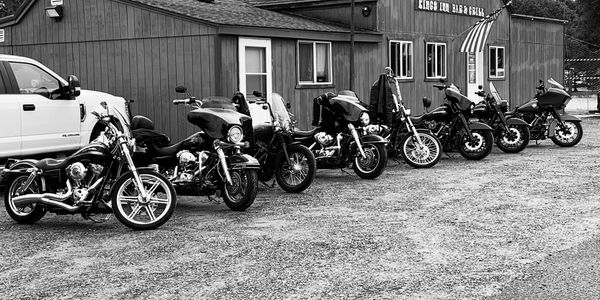 Motorcycles parked outside Kings Inn Bar & Grill with a pickup truck nearby.