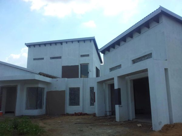 Unfinished modern white house with multiple sections under construction.