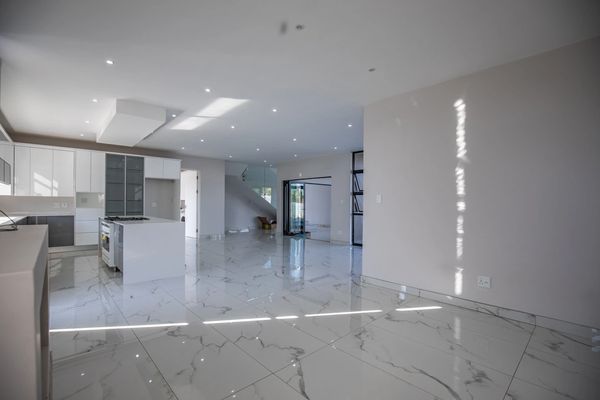 Spacious modern kitchen with marble floors and bright recessed lighting.