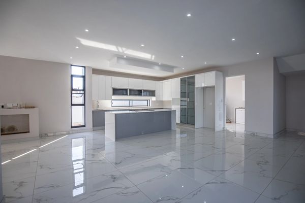 Modern kitchen with marble flooring and white cabinets.