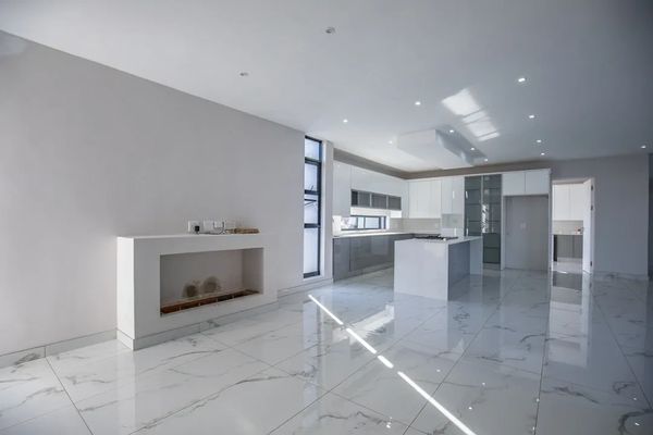 Modern kitchen with white marble floors and sleek cabinetry.