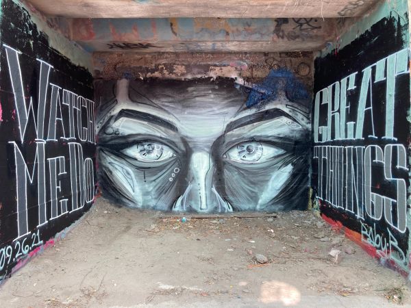 Black and white graffiti of eyes with motivational text on either side.