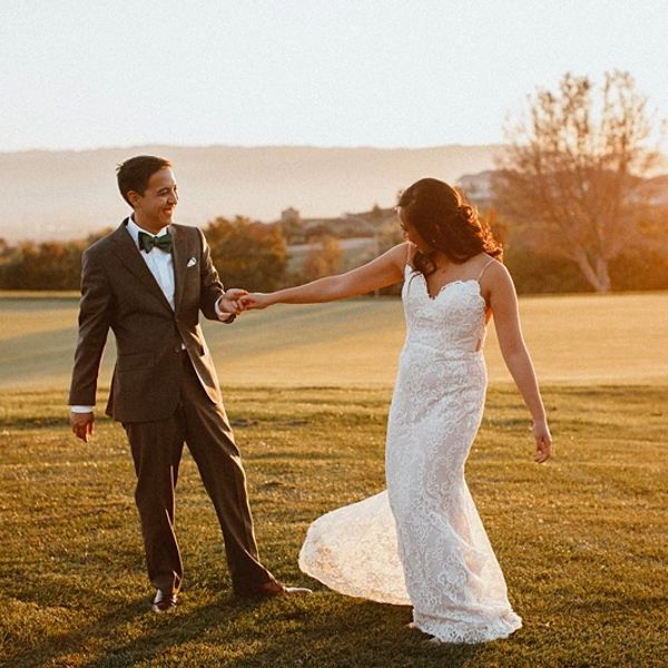 Bride and groom dancing outdoors at sunset on their wedding day.