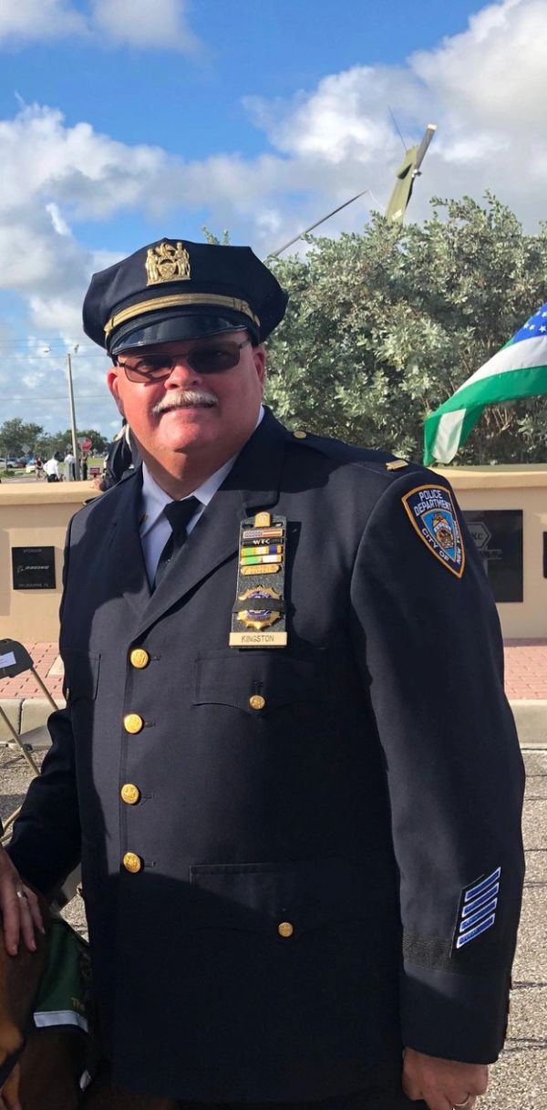 Smiling police officer in uniform outdoors.