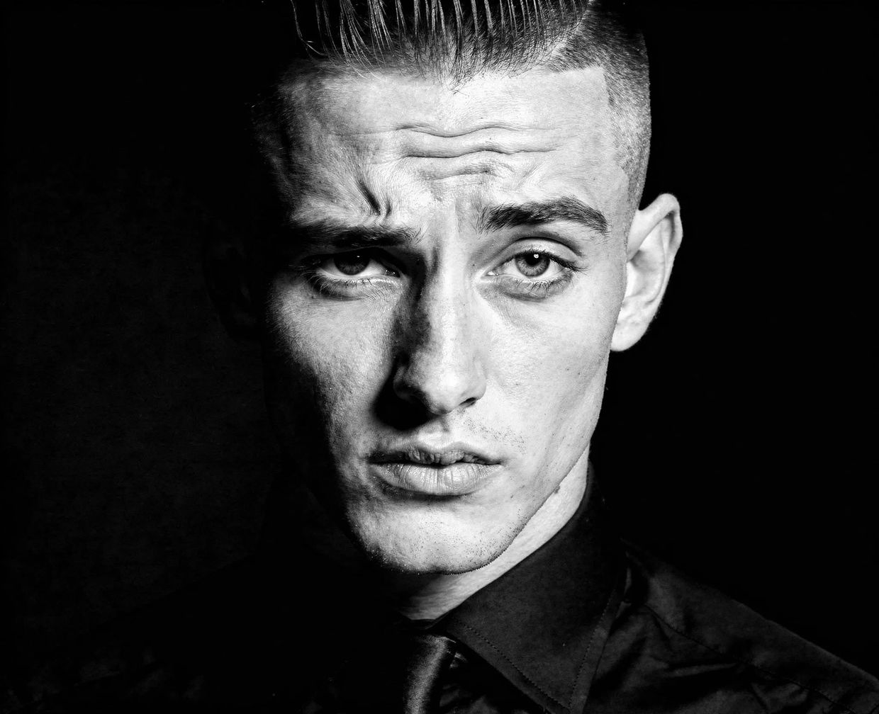 Black and white studio portrait of a young man — AI-generated synthographic artwork by davidname.