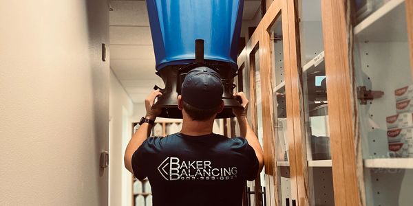 A test and balance technician using a flow hood to take a CFM reading from a diffuser.