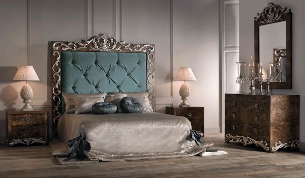 Elegant vintage bedroom with tufted headboard and ornate furniture.