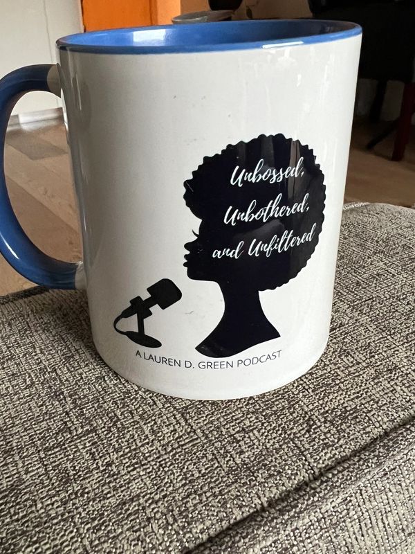 White 10oz. mug with  blue accent on handle and interior. Exterior front is centered Unbossed, Unbot