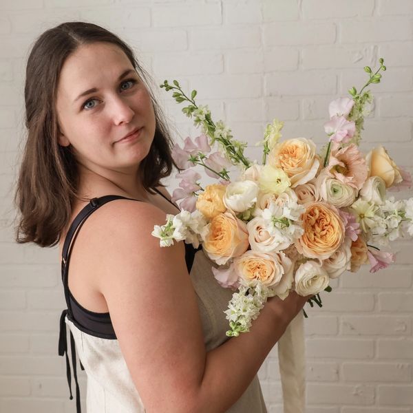 A woman in a dress holding a bridal bouquet