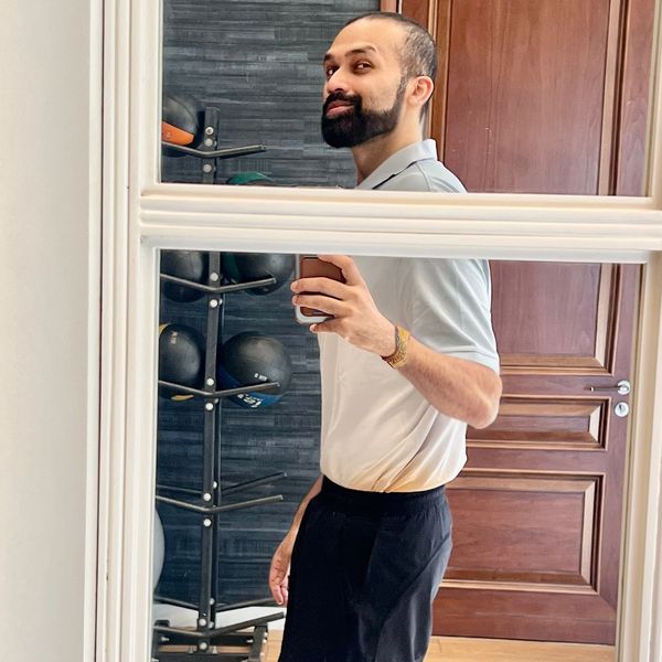 Man taking a mirror selfie in a room with wooden doors.