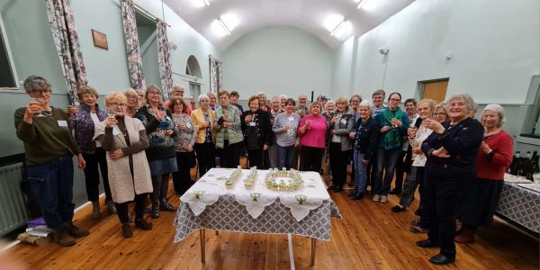Group of people celebrating with drinks around a table.