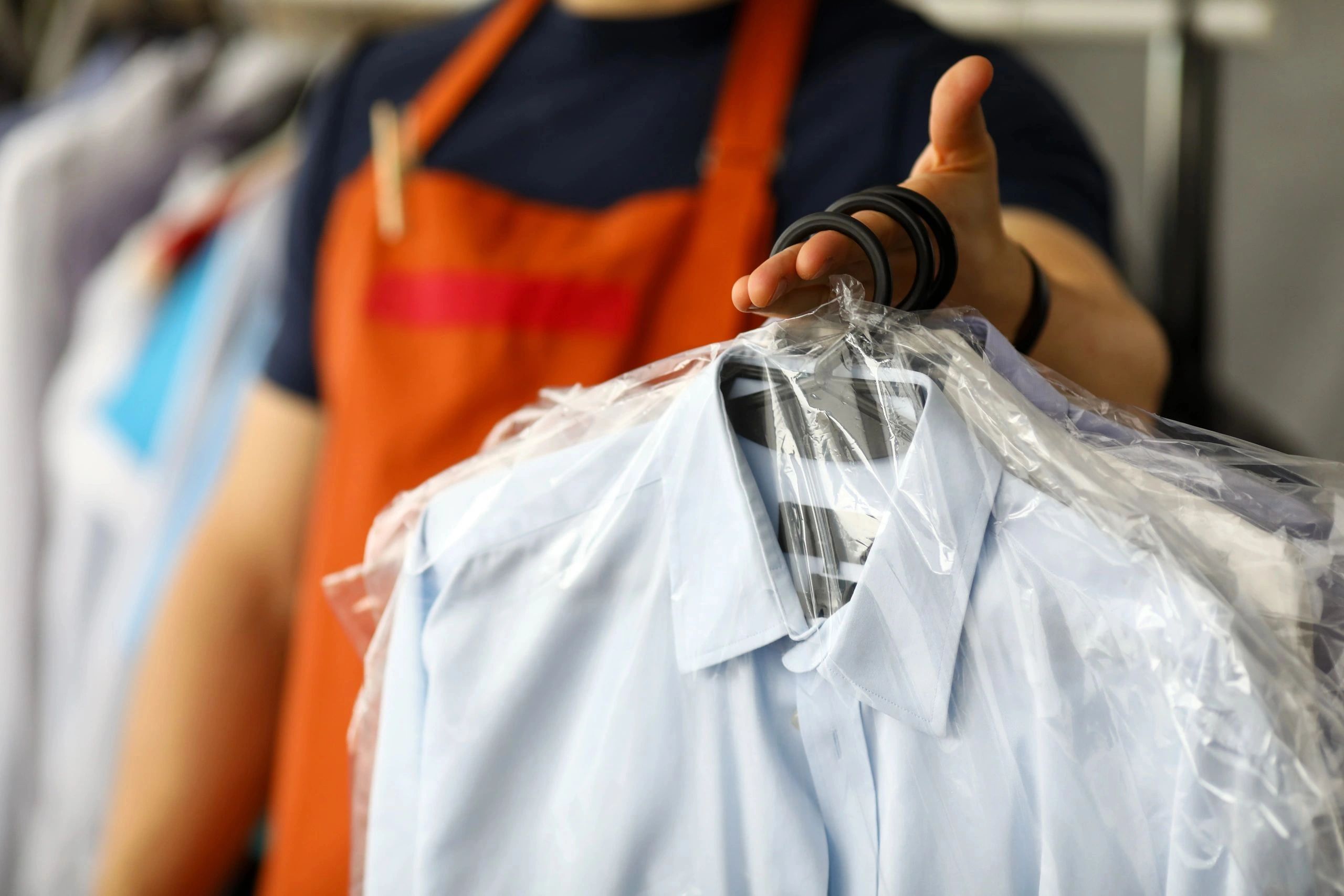 Clerk handing a dry cleaning order to customer