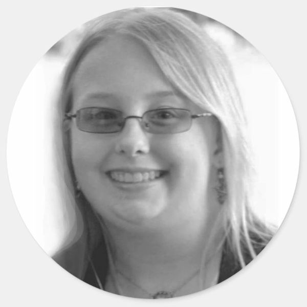 Smiling woman wearing glasses in a black and white portrait.