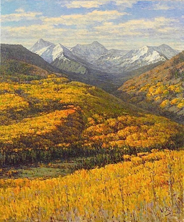 Autumn mountain landscape with golden trees and snow-capped peaks.