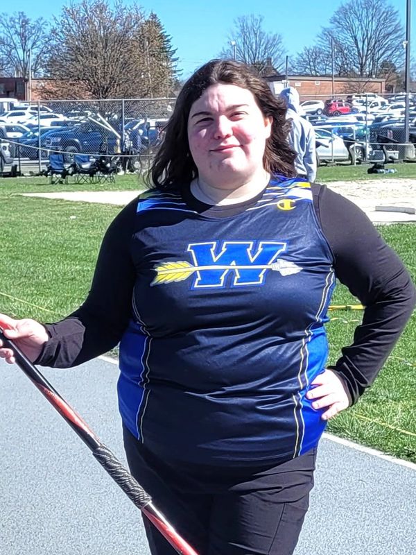 Athlete in blue and black sportswear holding a javelin.