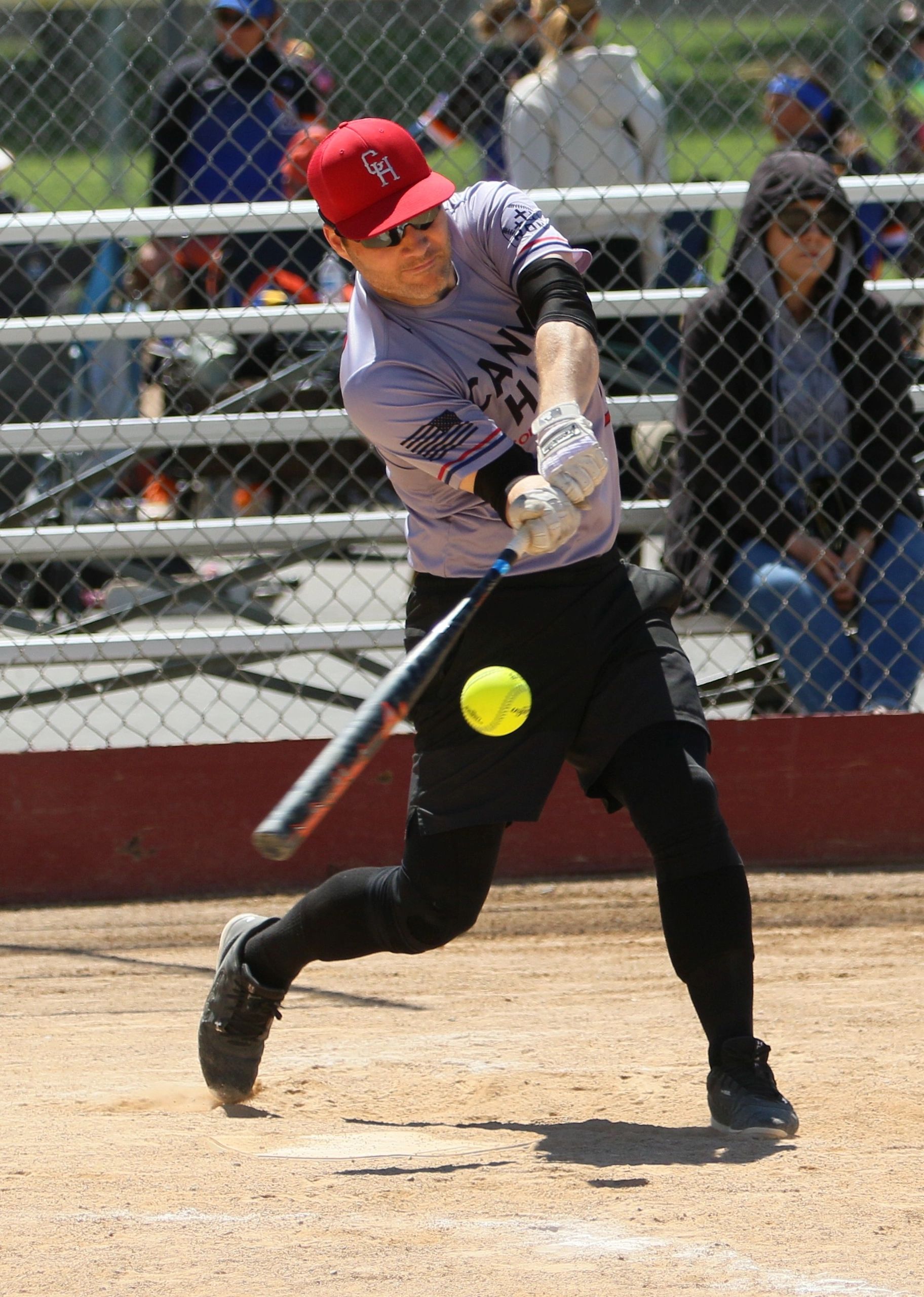 Baseball player hitting a softball during a game.