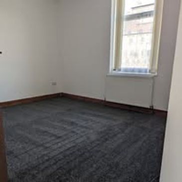 Empty room with dark carpet and window.