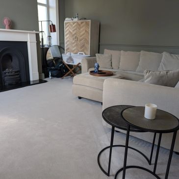 Cozy living room with beige sofa and nested tables.