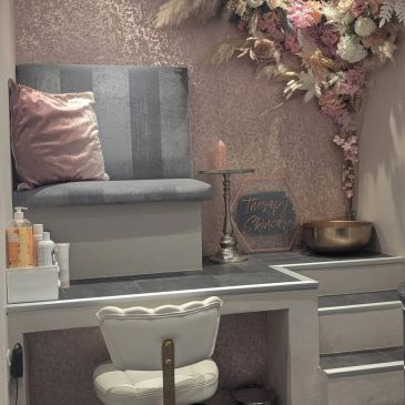 Cozy nail salon corner with floral decor and comfy seating.