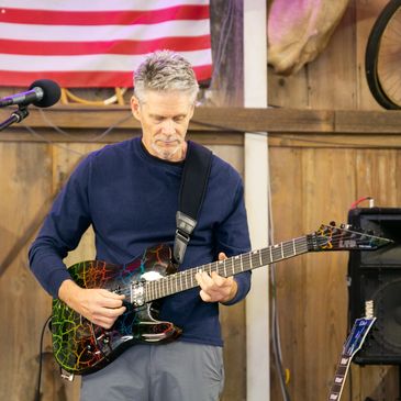 Man playing electric guitar indoors.