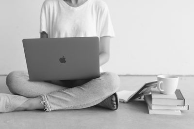 Woman on computer next to books