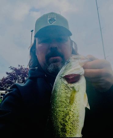 Man holding a largemouth bass fish he caught.