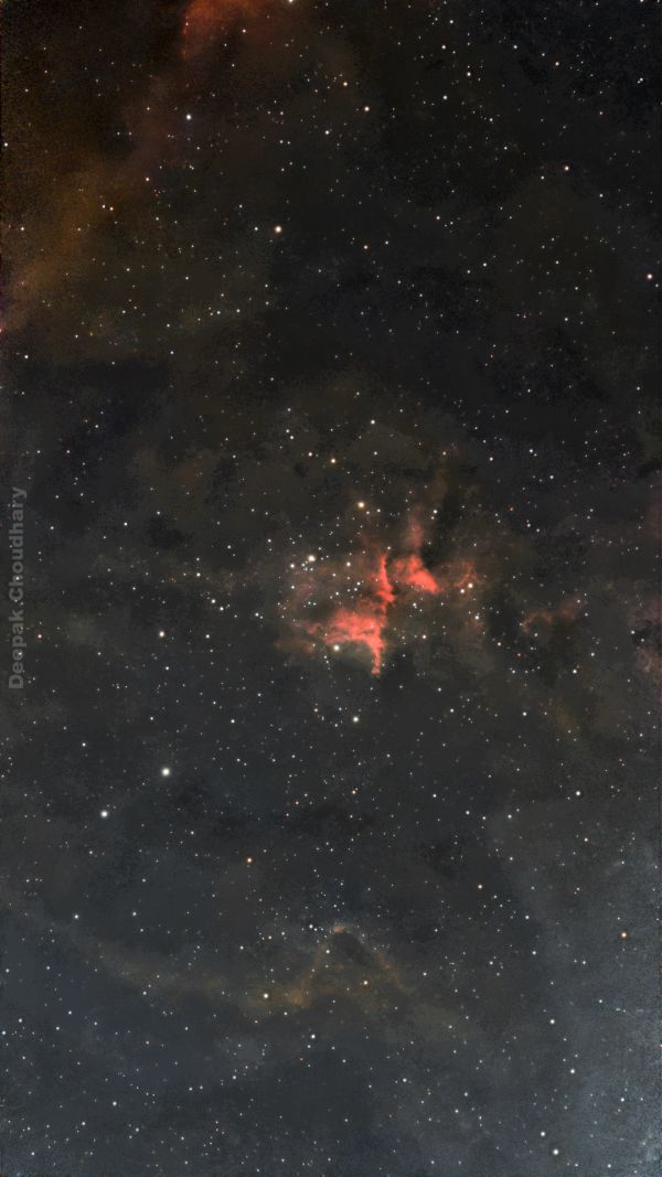 Bright red nebula with numerous stars in the dark sky.