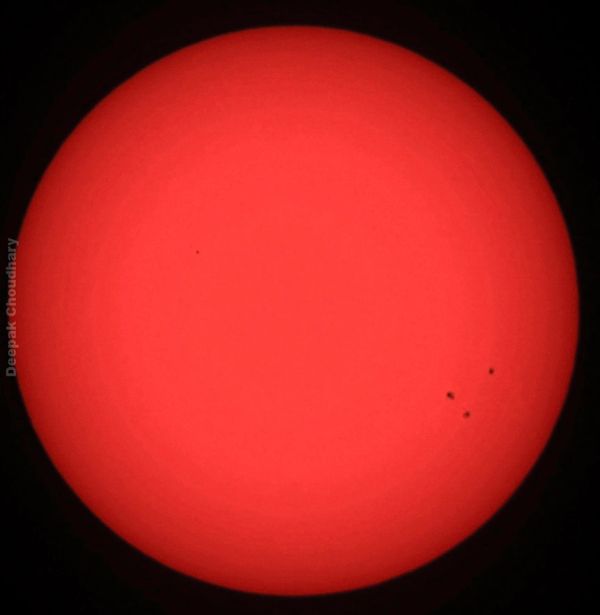 The red sun with visible sunspots.