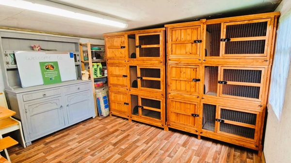 A tidy room with wooden animal cages and a grey cabinet.